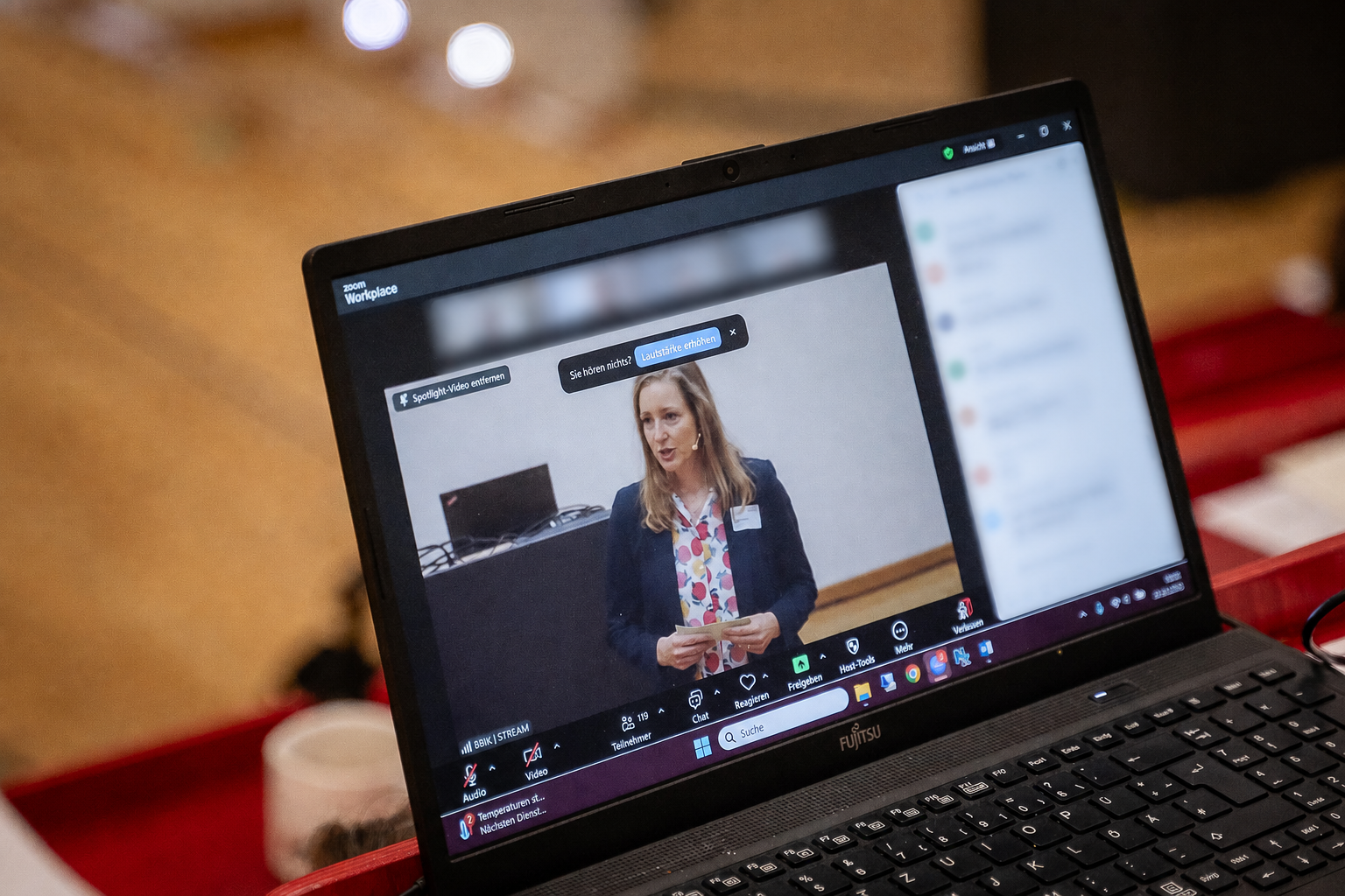 Carolin Kleist auf einem Laptopbildschirm beim Tag des nachhaltigen Planens und Bauens; weitere Teilnehmende sind unkenntlich gemacht